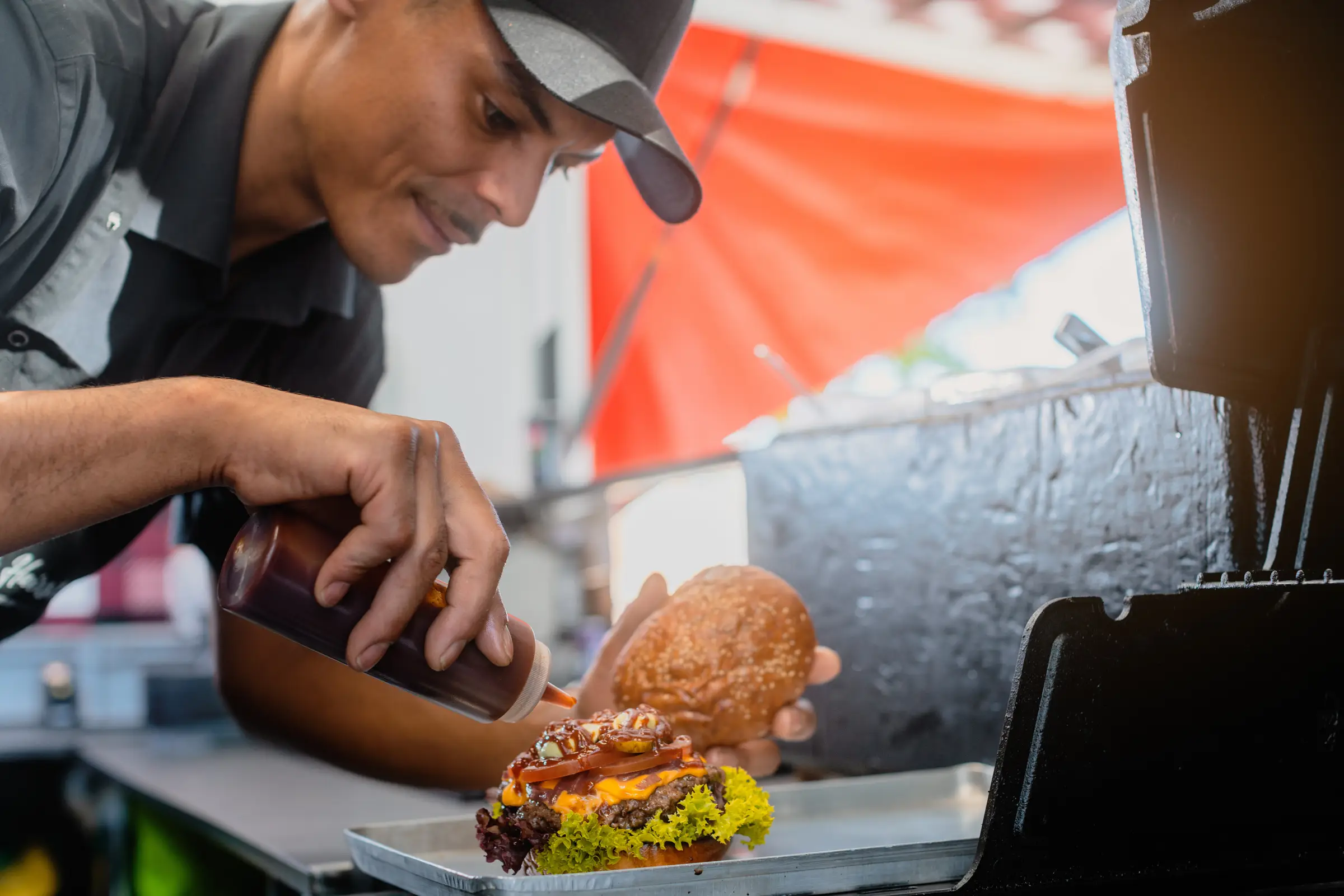 Koch bereitet einen Burger zu